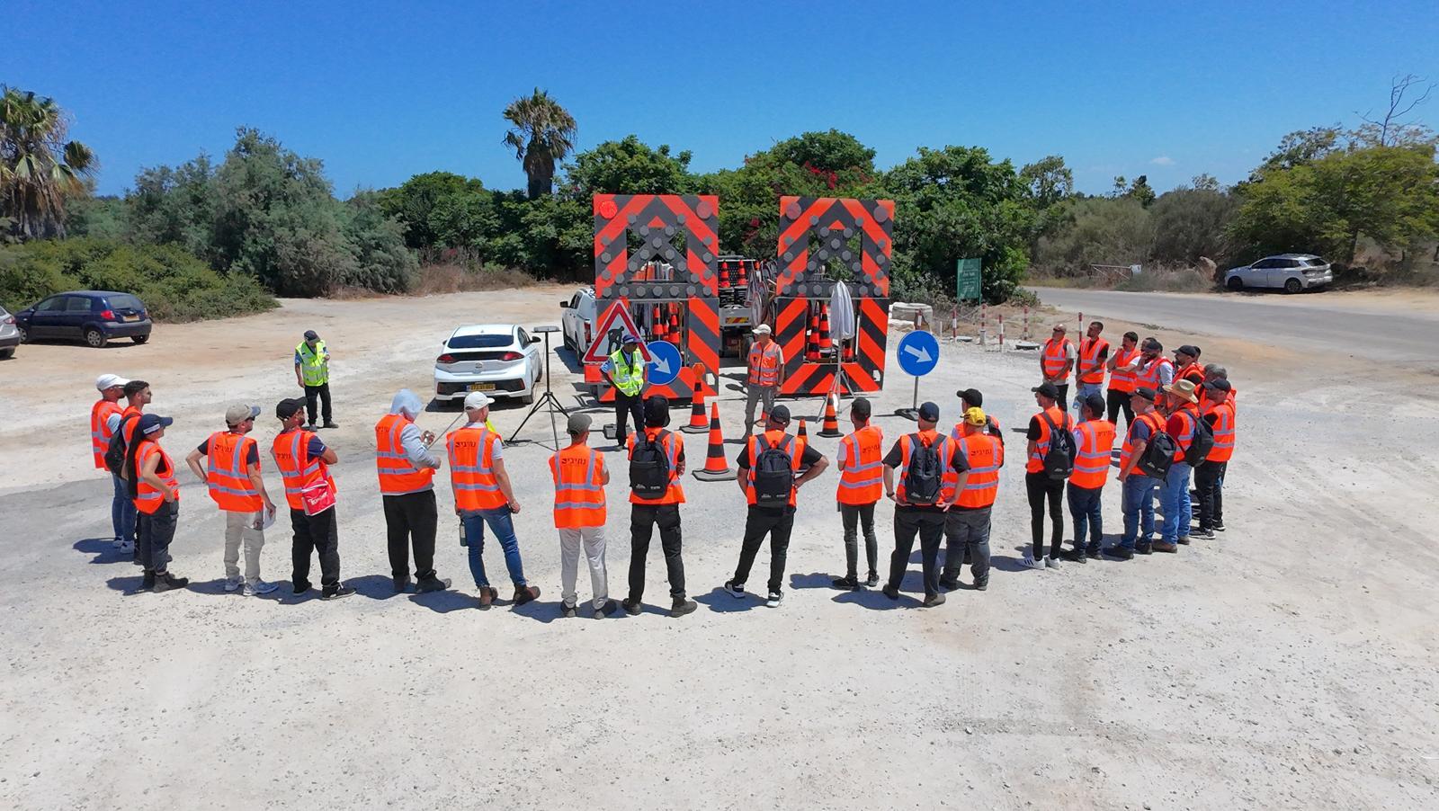 A professional leading a field session with inspectors around temporary traffic-control equipment